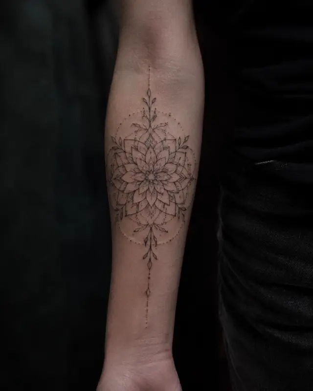 Fine line ornamental mandala tattoo with dotwork on a forearm
